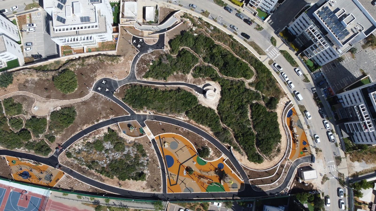 מבט עליון על שבילים ומתקני משחק בפרויקט בחריש